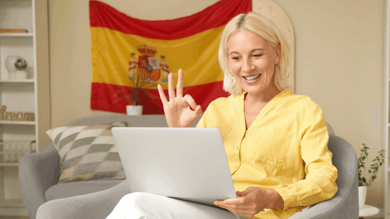 Online spanyol órán részt vevő nő, aki laptop előtt gyakorolja a spanyol nyelvet az otthonából.